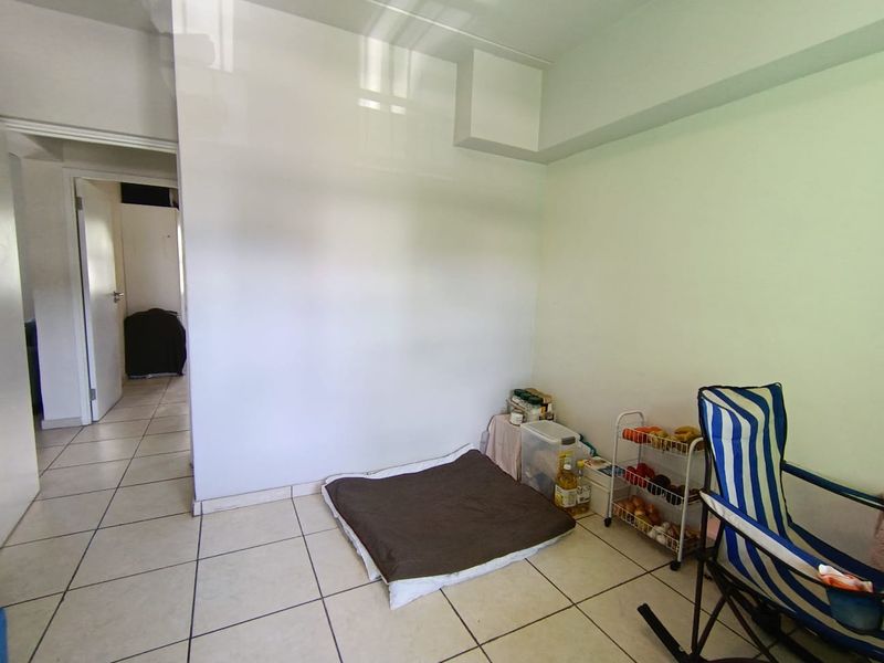 A neutral, tiled living area with clean white walls, offering a blank canvas for personalization and interior design.