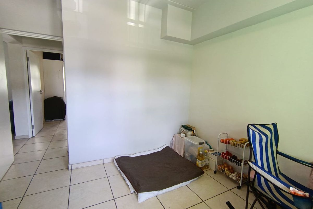 A neutral, tiled living area with clean white walls, offering a blank canvas for personalization and interior design.
