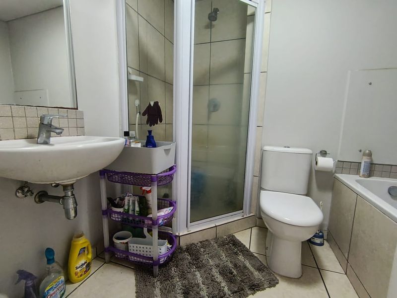 A functional bathroom featuring a pedestal basin, a separate shower enclosure, a toilet, and a bathtub with tiled finishes.