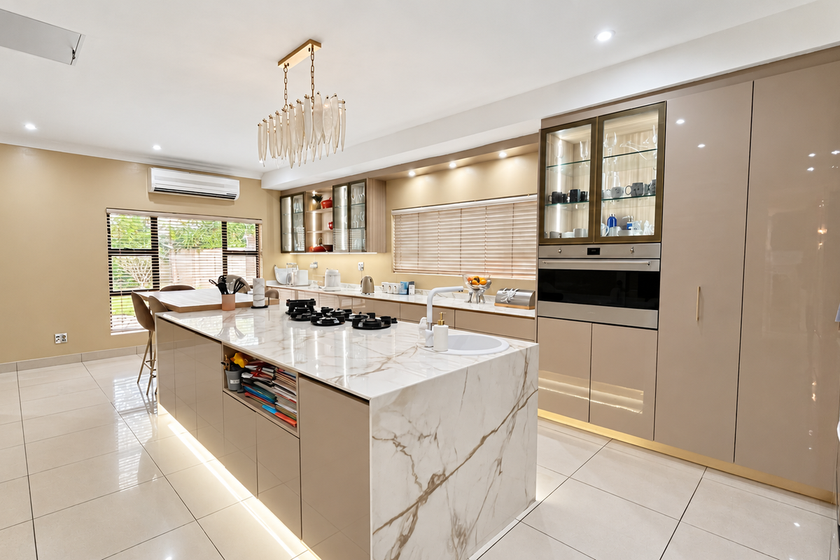 Modern kitchen featuring a marble-look island with gas cooktop, integrated cabinetry, built-in oven, and high-end finishes throughout.