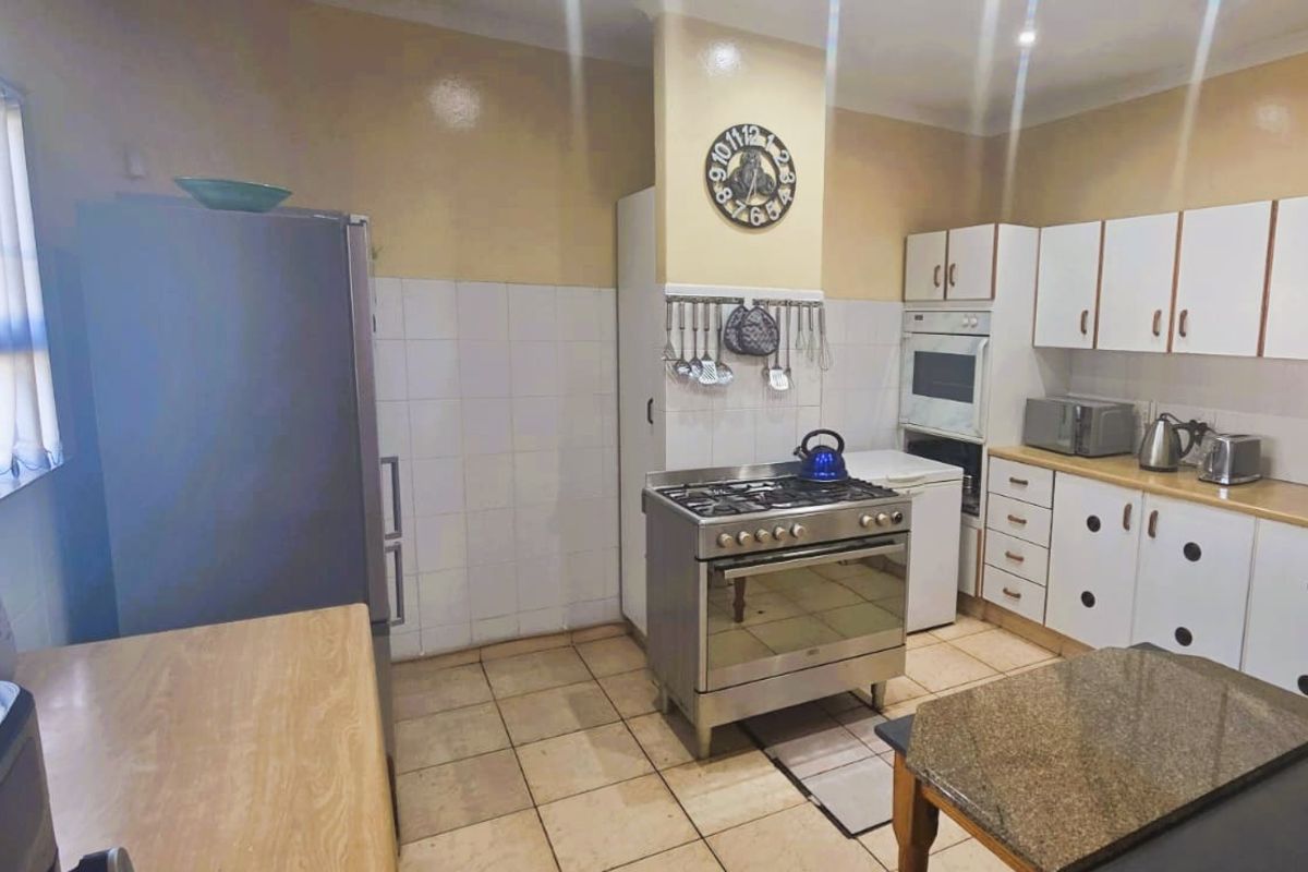 A functional kitchen featuring white cabinetry, tiled backsplash, built-in oven, and gas hob, offering a practical layout with potential for modern updates.