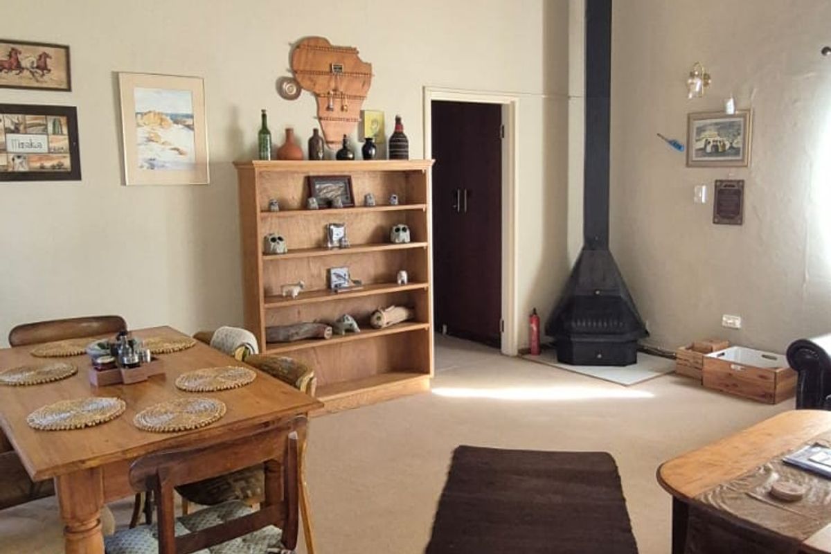 Spacious living area featuring high ceilings and a prominent built-in fireplace with a tall flue, creating a cozy and functional focal point.