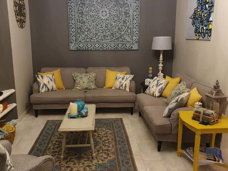 A cozy living room featuring tiled flooring and built-in recessed shelving, providing a comfortable and functional space for relaxation.