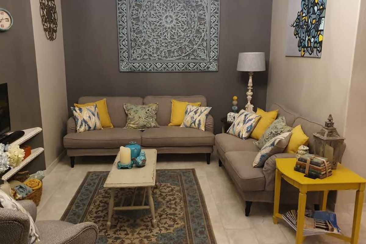 A cozy living room featuring tiled flooring and built-in recessed shelving, providing a comfortable and functional space for relaxation.