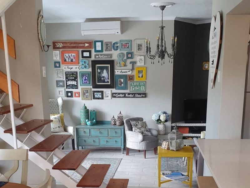 Open-plan living area featuring a modern staircase, split-system air conditioning, and tiled flooring, creating a functional and connected space.