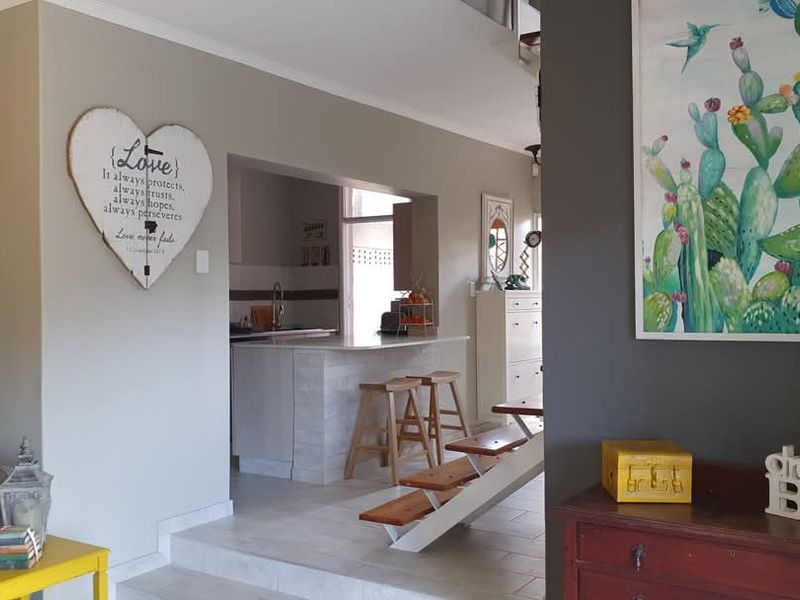 Open plan living area featuring a kitchen with a breakfast bar, tiled flooring, and a staircase leading to the upper level.