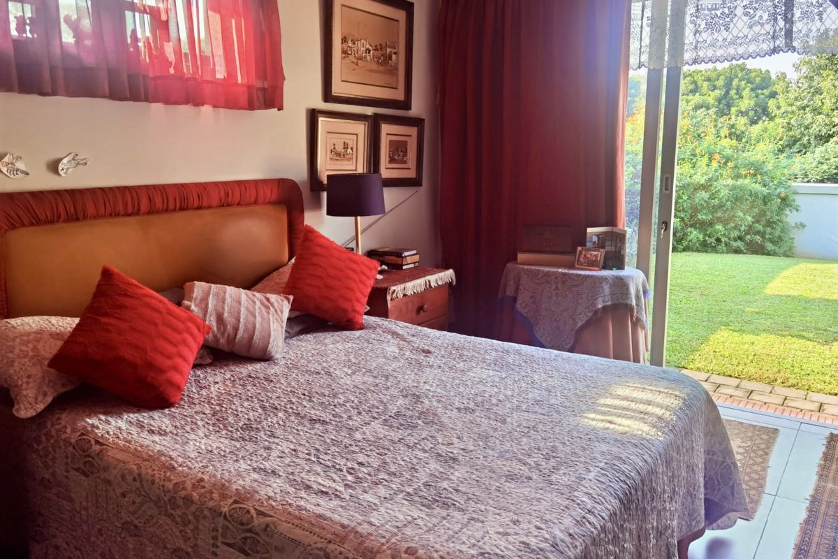 A bedroom featuring tiled flooring and a sliding glass door providing direct access to the garden area.