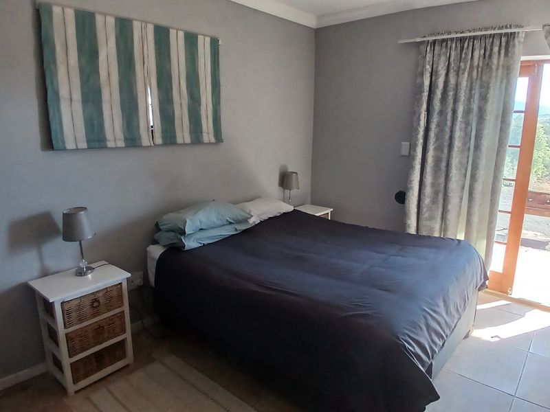A bedroom featuring tiled flooring and a glass sliding door providing access to the exterior, with neutral wall finishes.