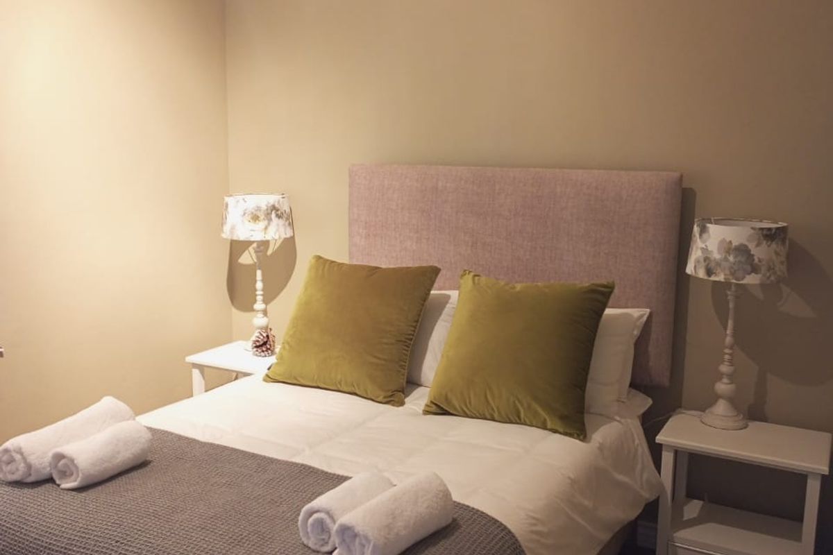 A cozy bedroom featuring neutral wall tones, crown molding, and carpeted flooring, providing a comfortable and well-maintained sleeping space.
