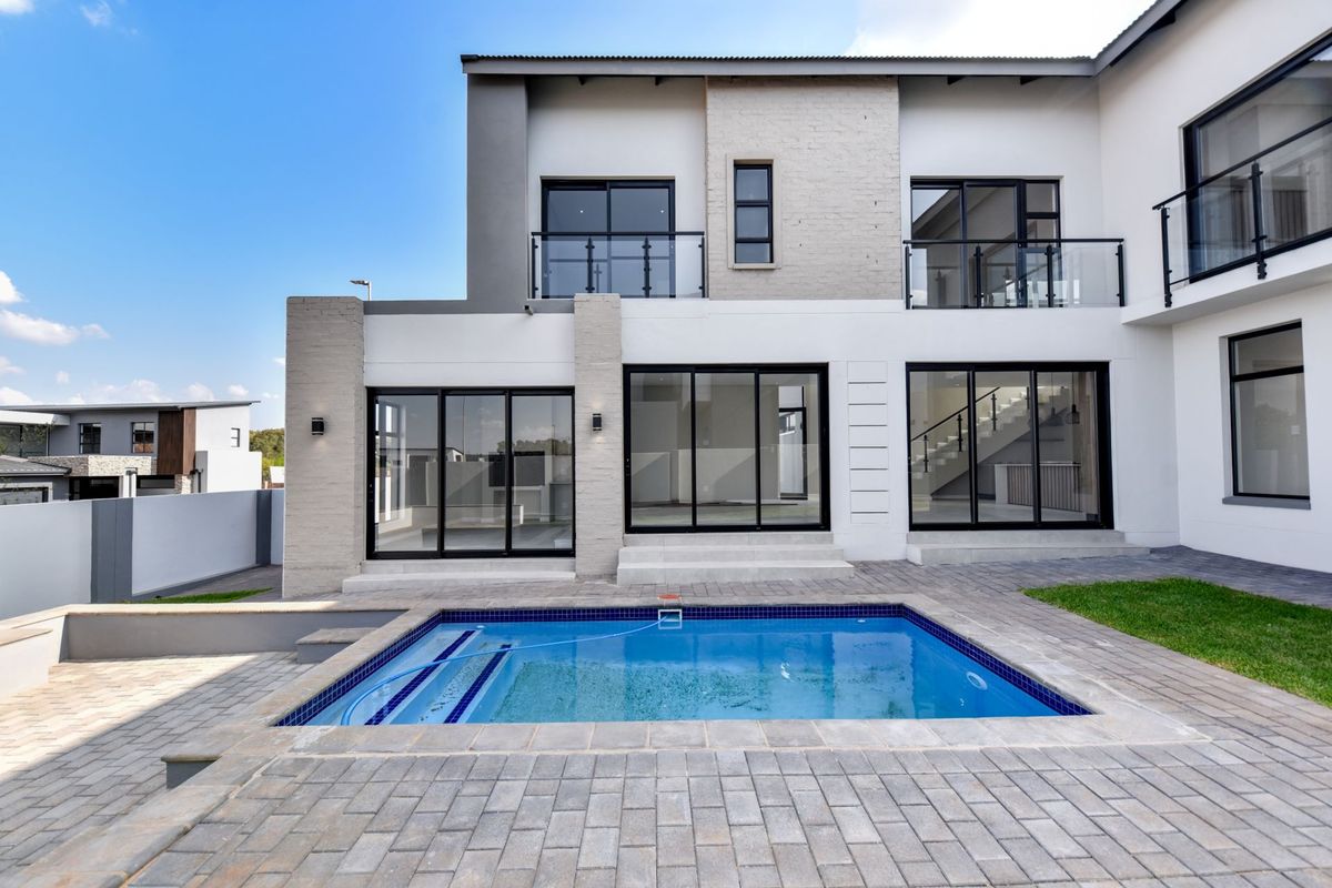 Modern double-story residence featuring a rear patio, swimming pool, and large sliding glass doors providing seamless indoor-outdoor flow.