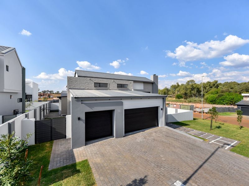 Modern double-story residential property featuring a double garage, paved driveway, and contemporary architectural finishes with a clean, well-maintained exterior facade.