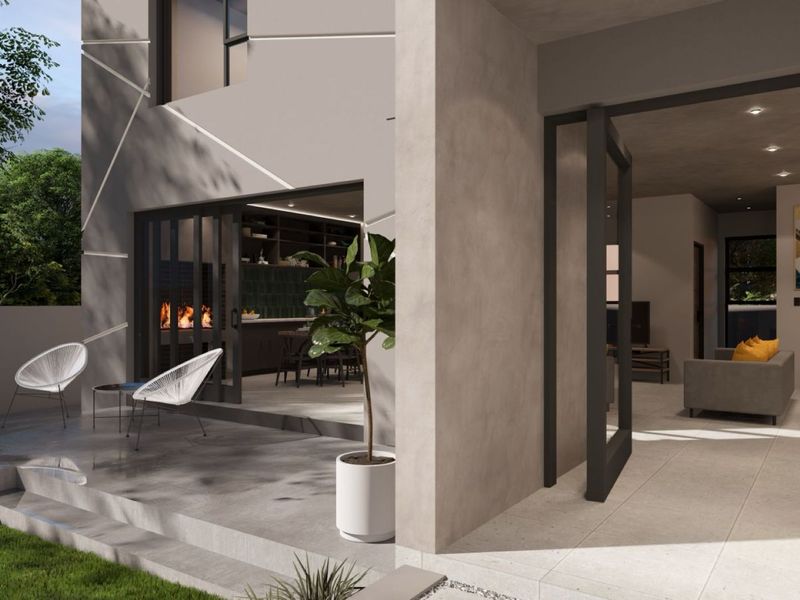 A modern covered patio area featuring large sliding glass doors that provide seamless indoor-outdoor flow to the living and kitchen spaces.