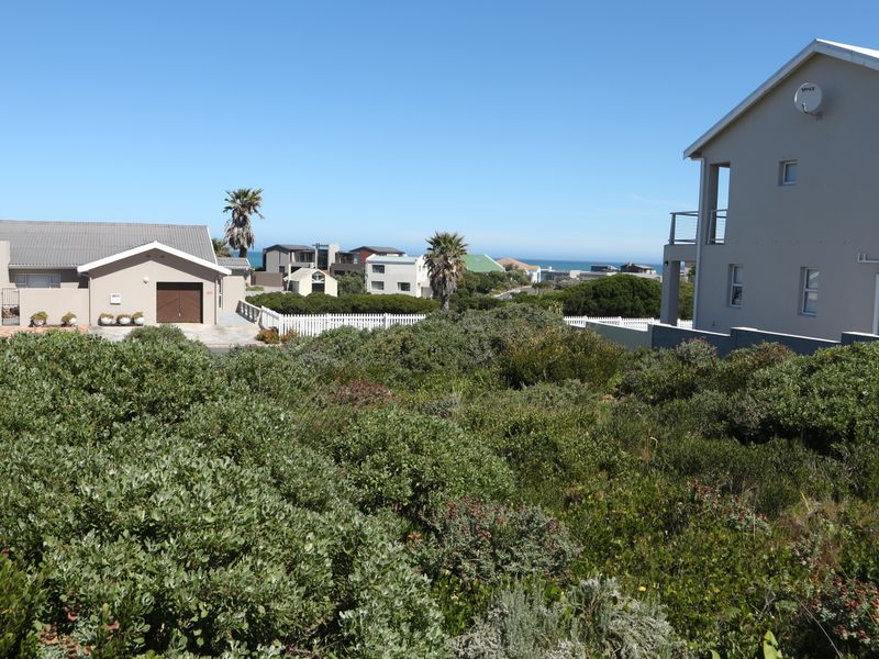 A scenic view overlooking a coastal residential neighborhood with established vegetation and surrounding homes.