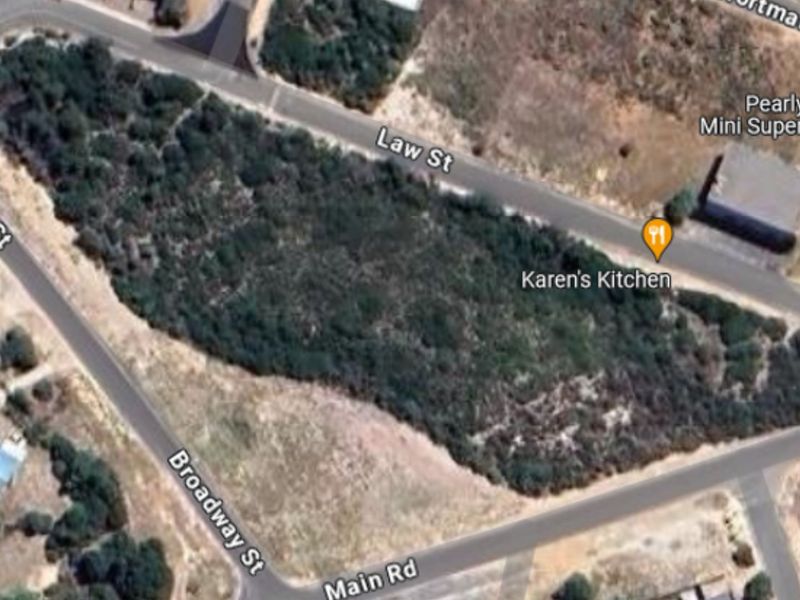 An aerial view of a vacant residential plot situated at the intersection of Law Street, Broadway Street, and Main Road.