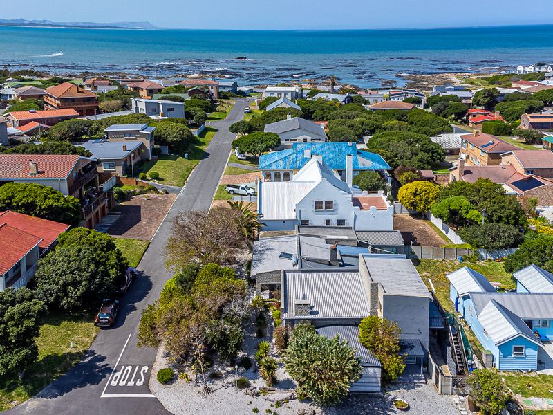 An aerial view of a coastal residential neighborhood, showcasing the proximity to the ocean and the surrounding street layout.