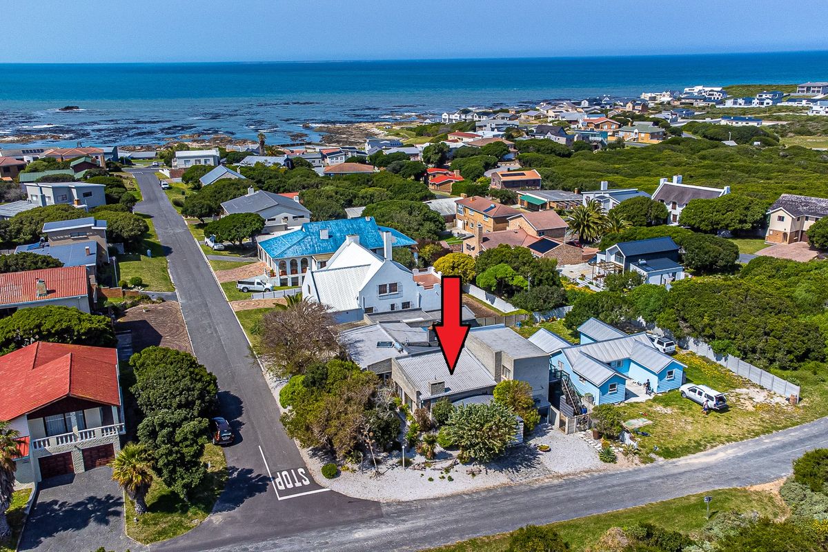 Aerial view of a coastal residential property, highlighting its proximity to the ocean and surrounding neighborhood layout.