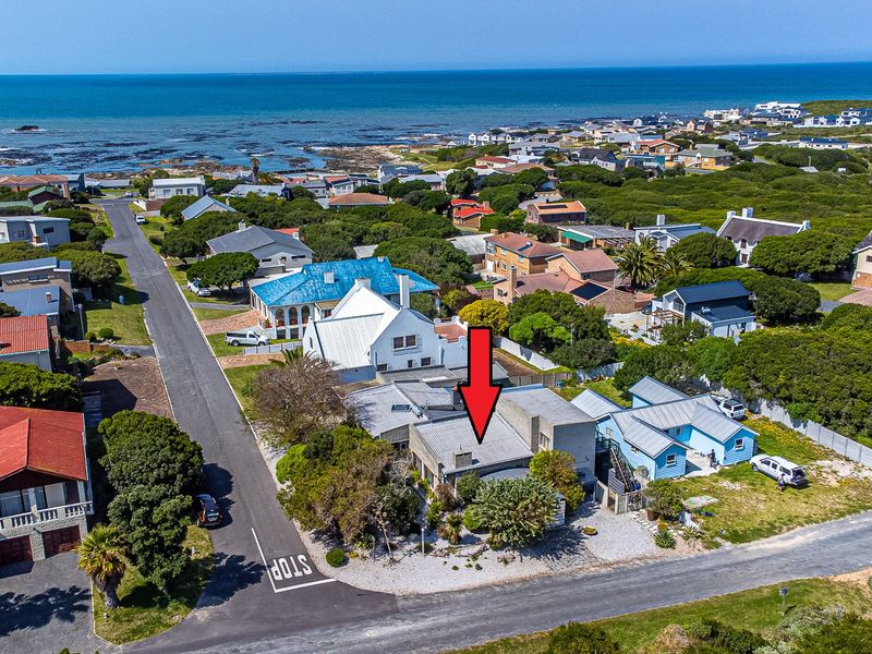Aerial view of a coastal residential property, highlighting its proximity to the ocean and surrounding neighborhood layout.