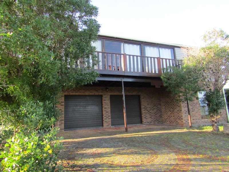 Front view of a two-story brick house featuring a double garage and an elevated timber balcony.