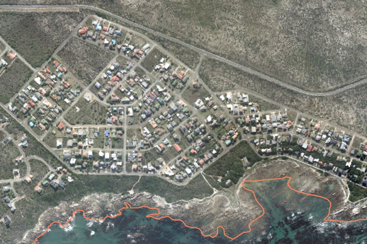 An aerial view of a coastal residential neighborhood showing the layout of properties in relation to the shoreline.