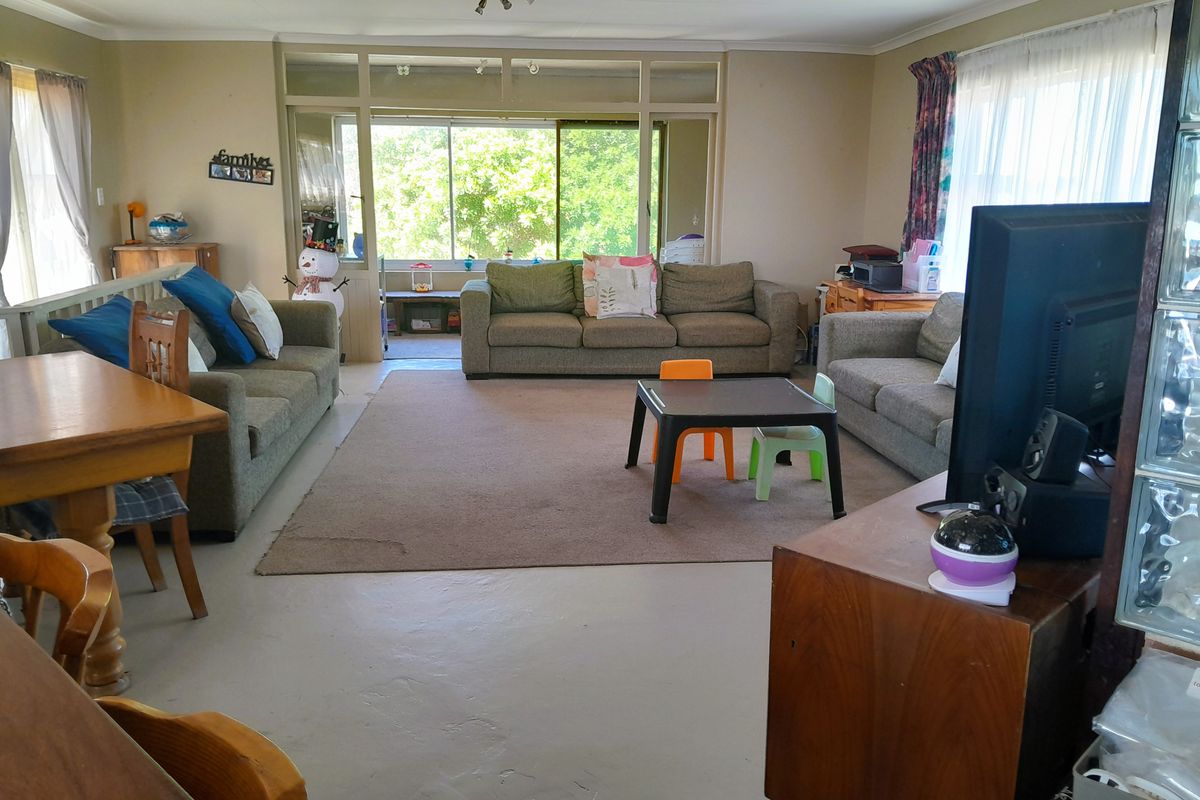 Spacious living area featuring a glass block partition and large sliding doors that provide access to an adjoining sunroom or patio space.