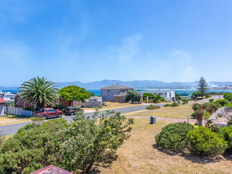 A scenic elevated view overlooking the coastal neighbourhood, surrounding landscape, and distant mountain range.