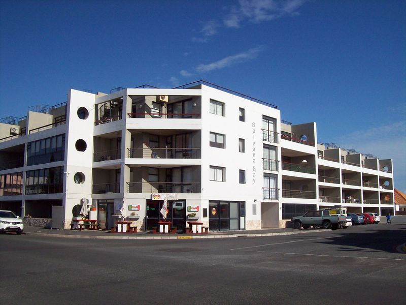 Exterior view of the Baleana Bay apartment complex, featuring multi-level balconies, modern architectural design, and ground-level commercial access.