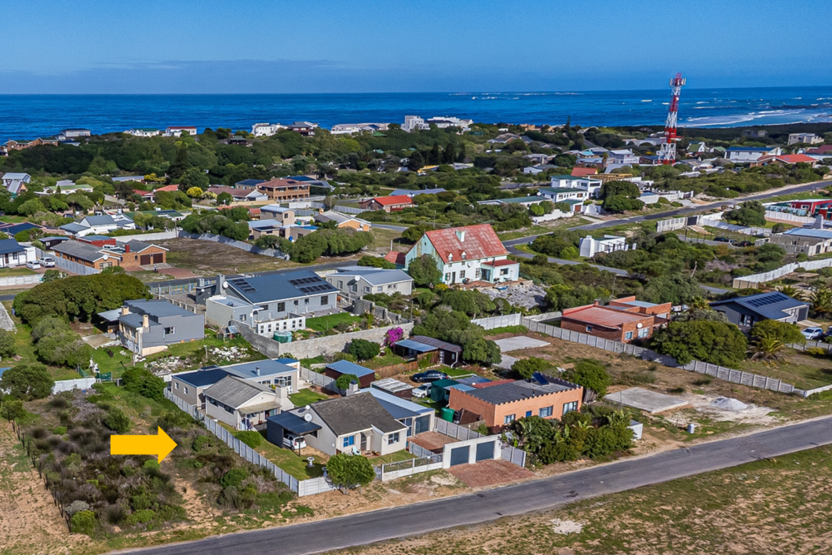 Aerial view of a coastal residential property showing the house, surrounding neighborhood, and proximity to the ocean.