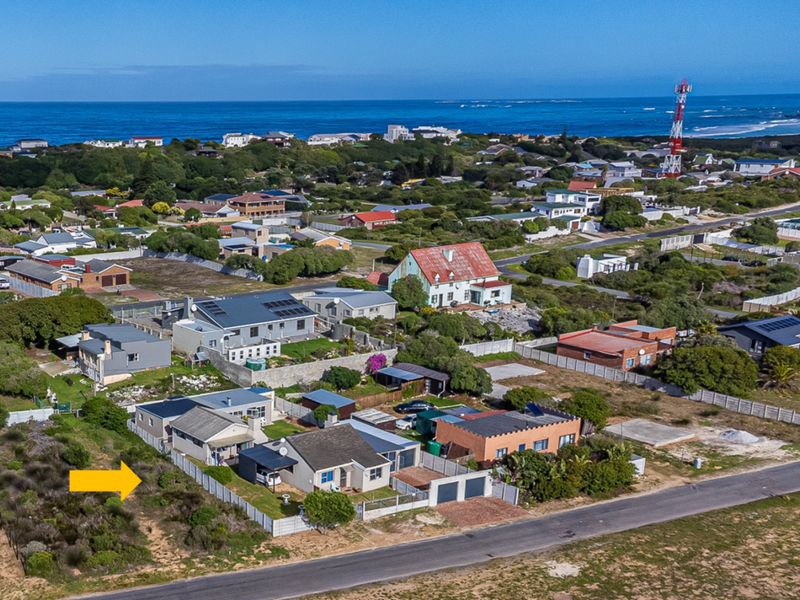 Aerial view of a coastal residential property showing the house, surrounding neighborhood, and proximity to the ocean.