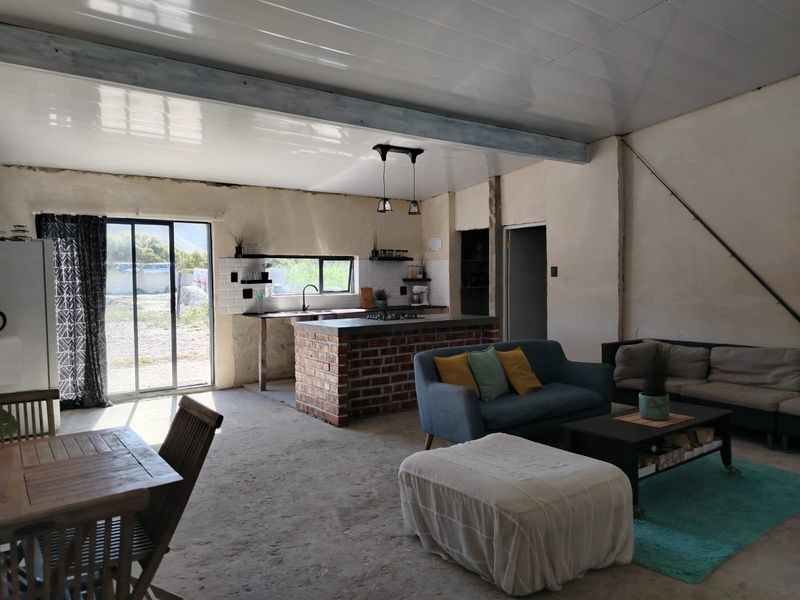 Open-plan living and kitchen area featuring an exposed brick island, gas cooktop, and direct access to the outdoors via sliding glass doors.