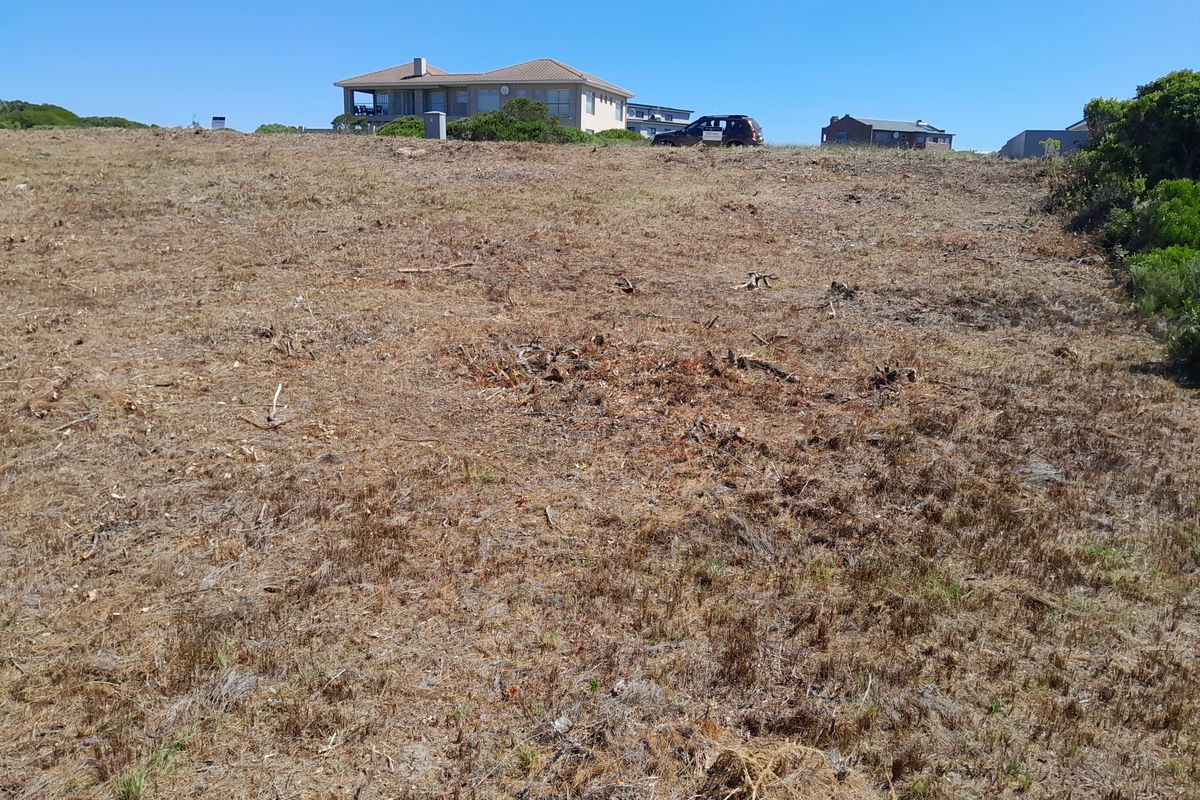 A vacant residential plot of land with cleared vegetation, offering a clear building site with surrounding neighborhood views.