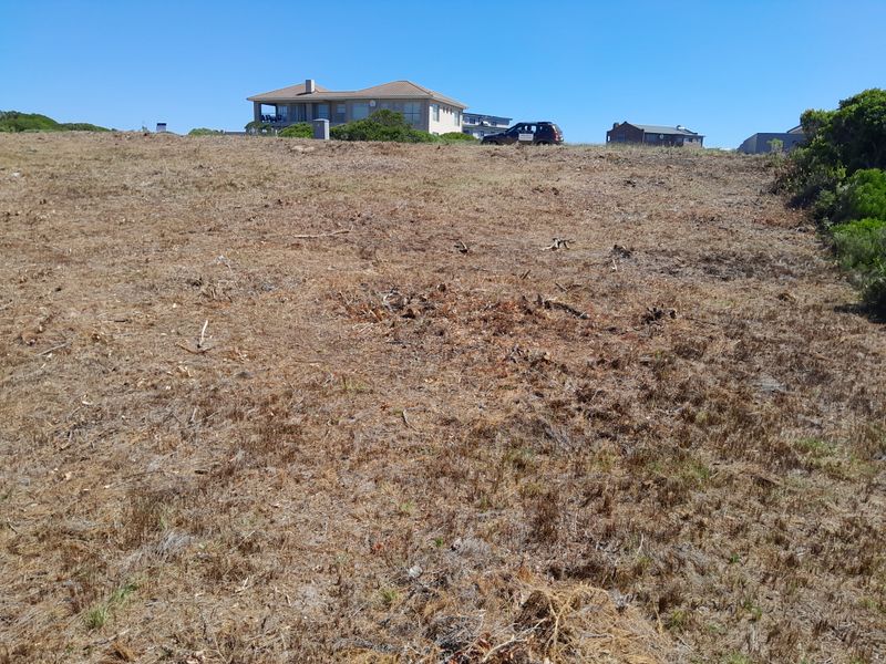 A vacant residential plot of land with cleared vegetation, offering a clear building site with surrounding neighborhood views.