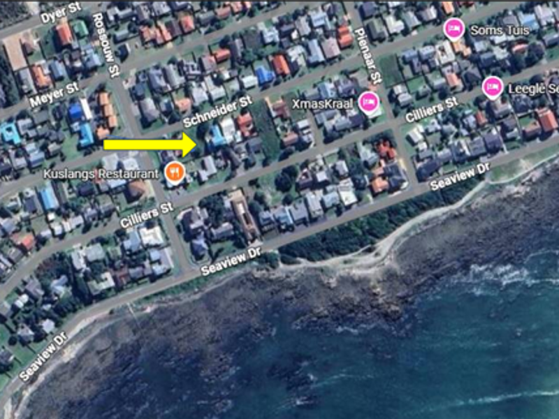 An aerial satellite view of the residential neighborhood showing the location of the property marked with a yellow arrow.
