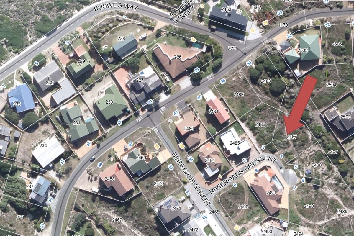 Aerial view of a vacant residential plot located in a developed coastal neighborhood, showing surrounding street layout and existing properties.