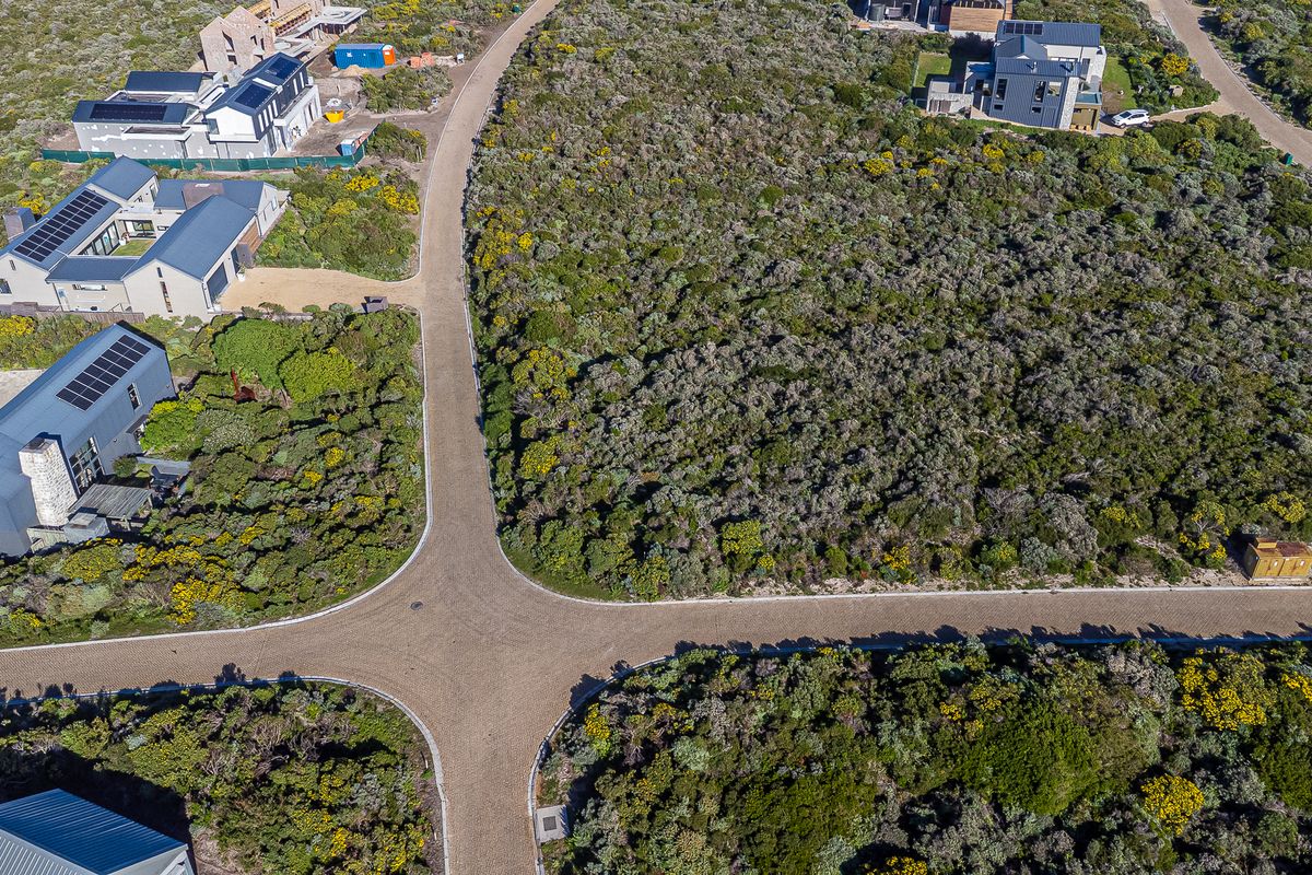 Aerial view of a residential estate showing paved roads and surrounding native vegetation with established neighboring properties.