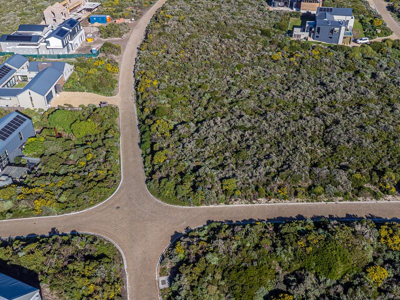 Aerial view of a residential estate showing paved roads and surrounding native vegetation with established neighboring properties.