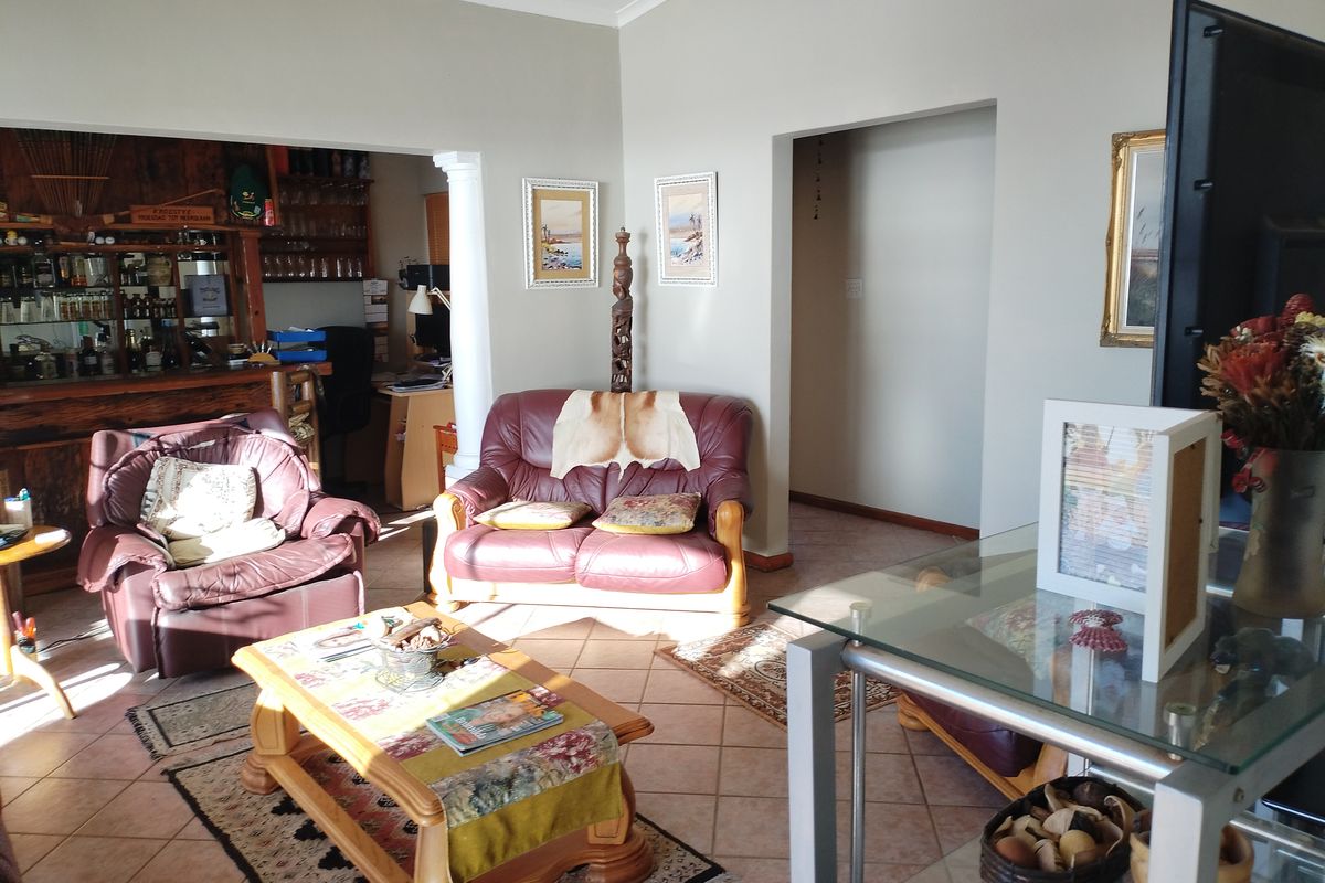 A living room featuring tiled flooring and a built-in bar area, providing a functional space with potential for modern updates.