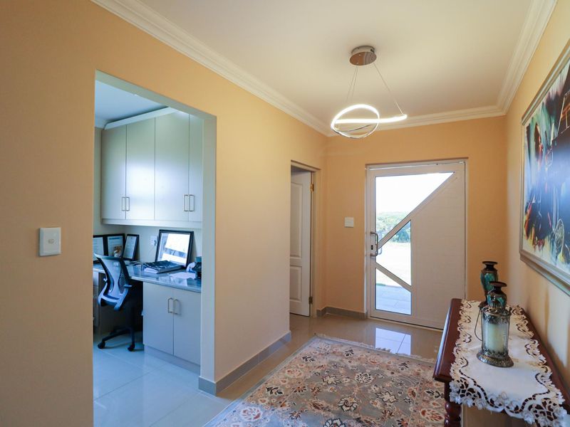 Welcoming entrance hall featuring tiled flooring, modern lighting, and a convenient built-in study nook with ample storage cabinetry.