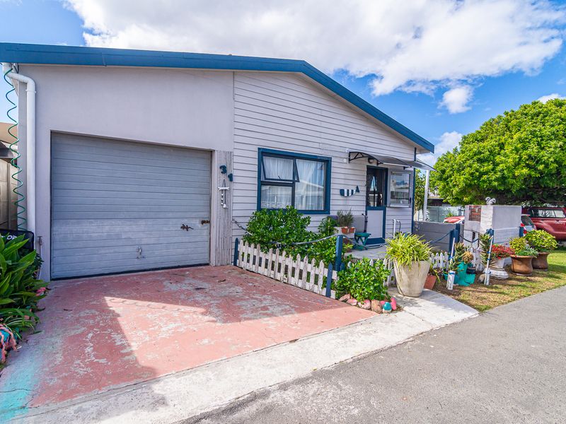 Front exterior view of the property featuring a single garage, weatherboard cladding, and a paved driveway area.