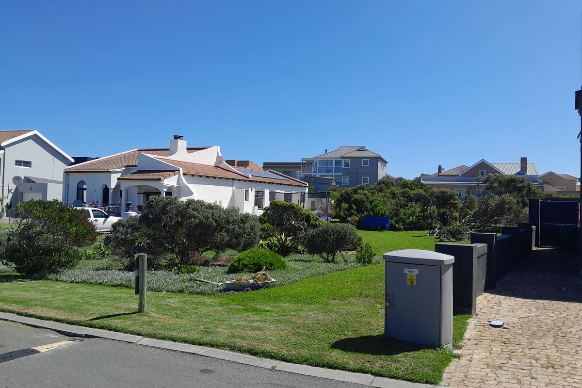 A view of the front garden and landscaped area of the residential property, featuring a paved driveway and established greenery.