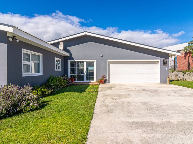 Front elevation of a residential property featuring a concrete driveway, single garage, and low-maintenance garden area.