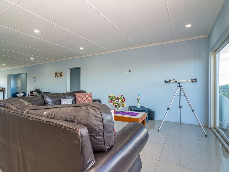 Spacious living area featuring tiled flooring, recessed downlighting, and large sliding glass doors providing natural light and access to the exterior.