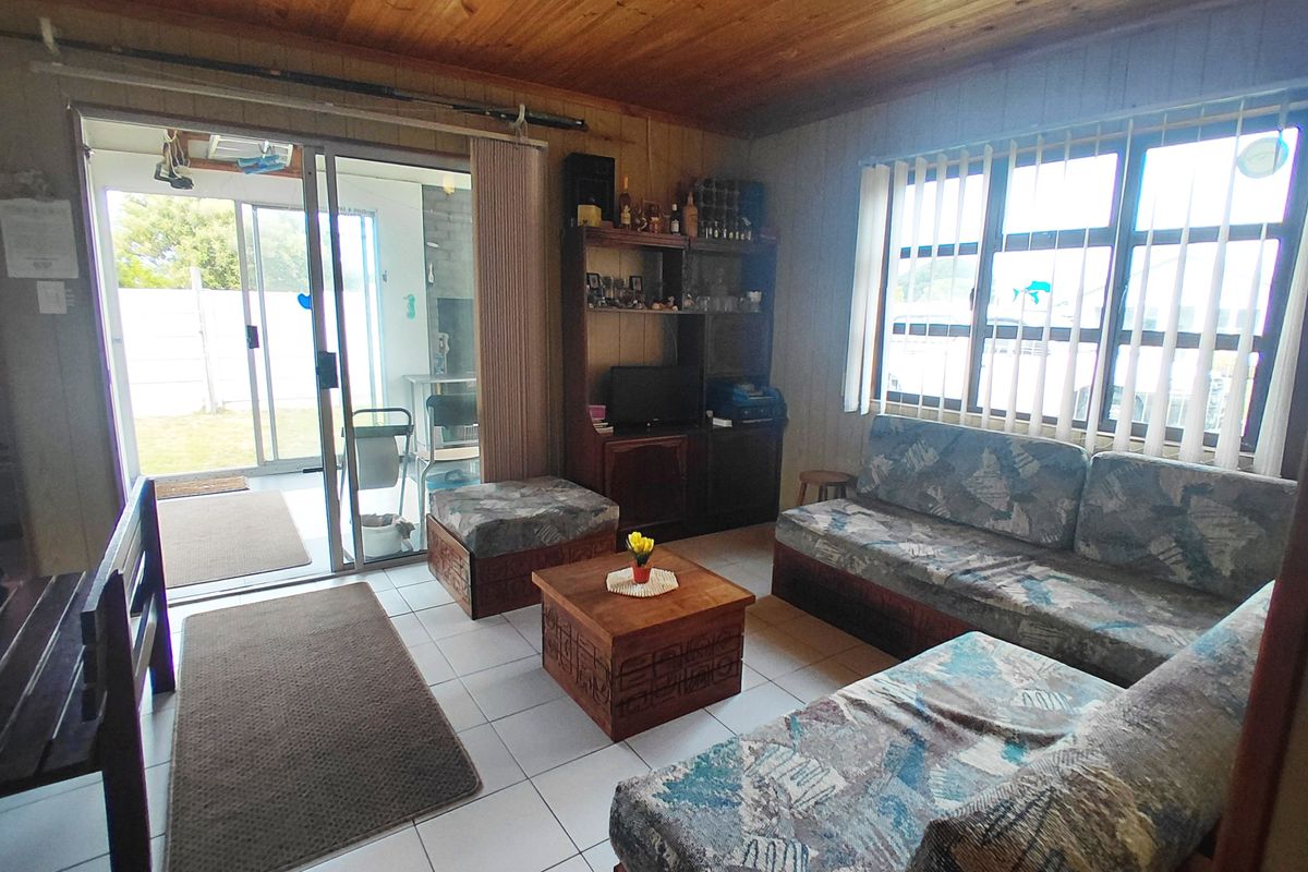 Living room featuring tiled flooring, timber ceiling, and sliding glass door access to the outdoor area.