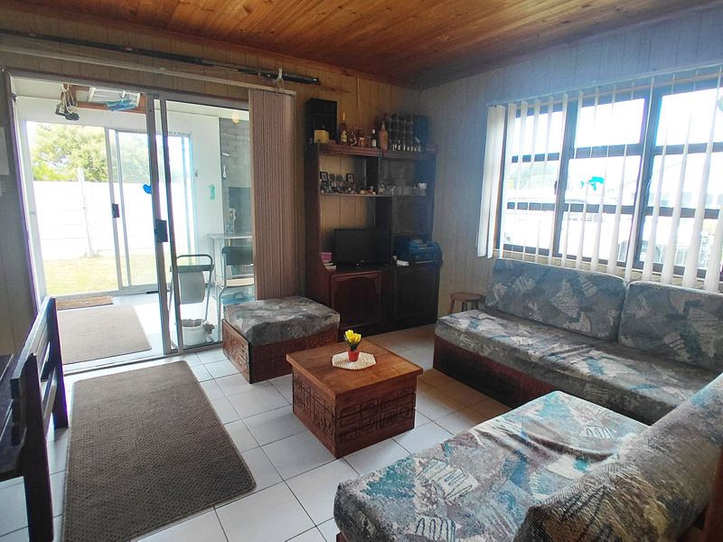 Living room featuring tiled flooring, timber ceiling, and sliding glass door access to the outdoor area.