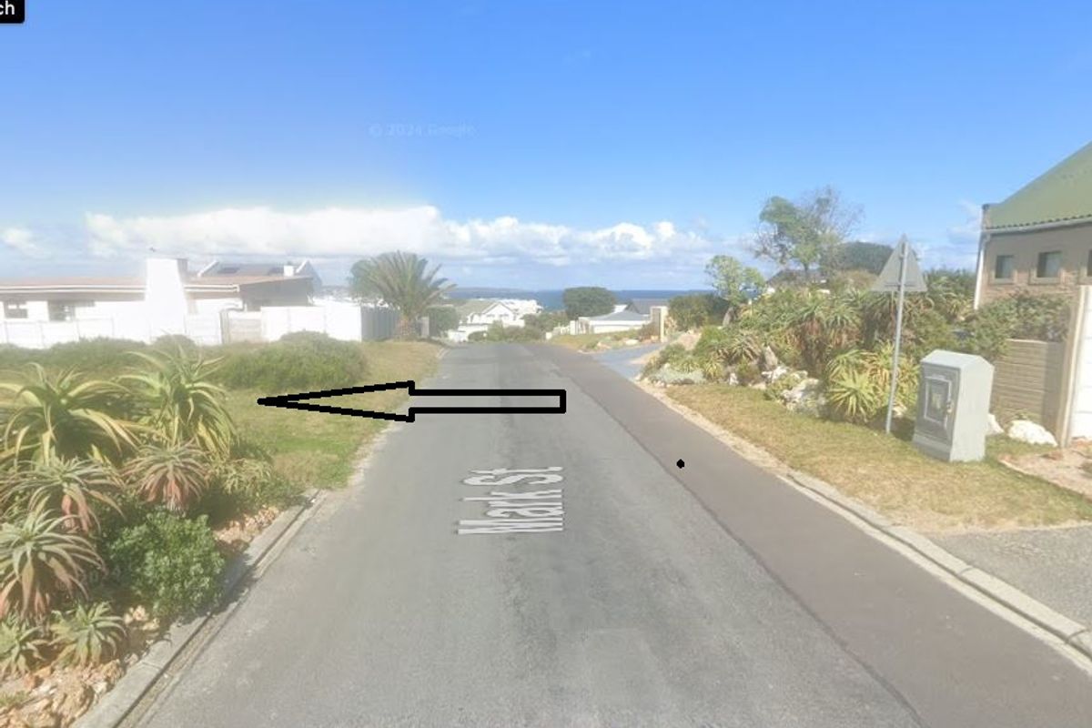 A street view of Mark Street showing the residential approach, paved road, and surrounding landscaped verges in a coastal neighborhood.