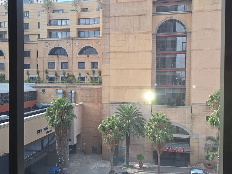A view from an office window overlooking a busy urban street and surrounding commercial buildings.
