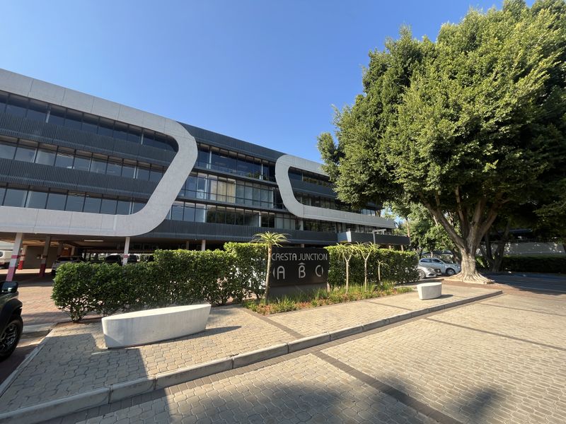 Exterior view of the Cresta Junction office complex featuring modern architectural facade, paved entrance area, and mature landscaping.