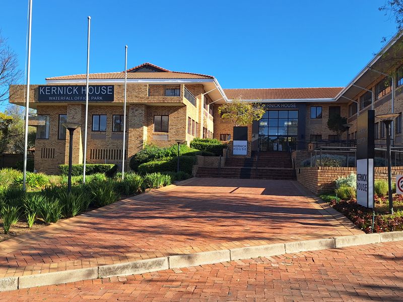 Front exterior view of Kernick House office building featuring a brick facade, tiled roof, and paved entrance driveway with landscaped surroundings.