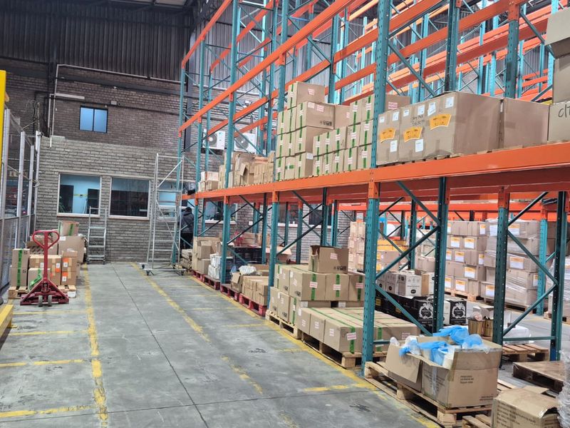 Industrial warehouse space featuring extensive steel racking systems, concrete flooring, and exposed structural elements, suitable for storage and logistics operations.