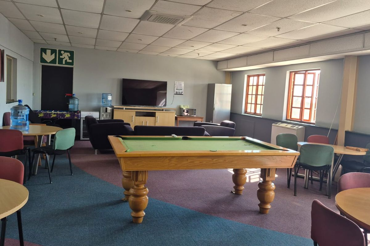 Spacious industrial break room or communal area featuring a suspended ceiling, air conditioning, and multi-purpose layout suitable for office or recreational use.