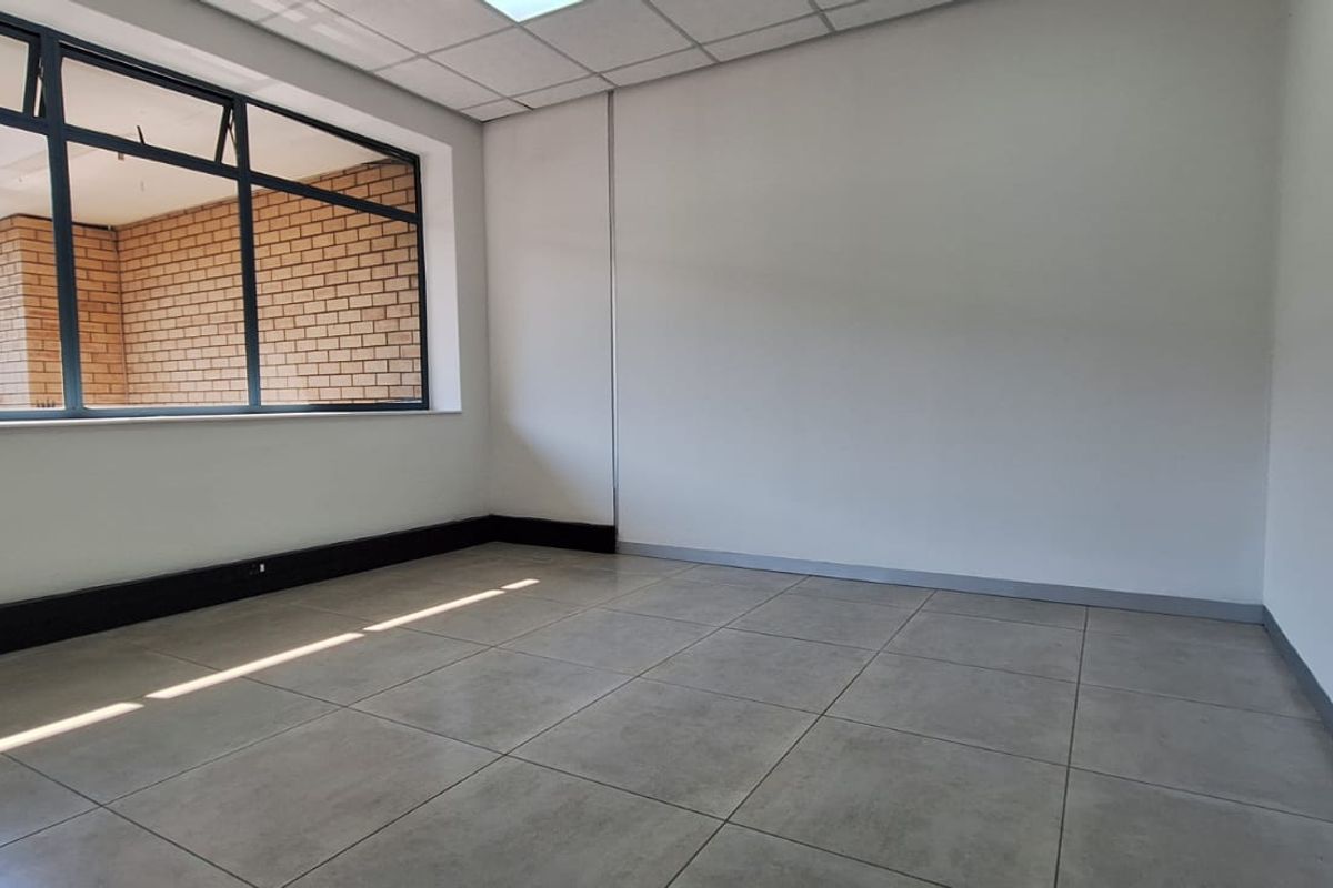 A bright, empty office space featuring large windows, modern tiled flooring, and a clean, neutral finish, ready for professional fit-out.
